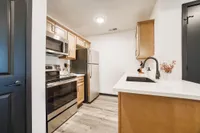 Contemporary kitchen featuring sleek stainless steel appliances, elegant wooden cabinetry, and a stylish white countertop with modern fixtures.