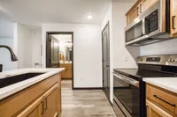 Modern kitchen with stainless steel appliances, sleek cabinetry, and adjoining bathroom, showcasing contemporary design.