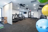 Modern fitness center with state-of-the-art cardio machines, free weights, and vibrant exercise balls, creating an energizing workout environment.
