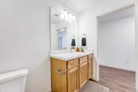 Elegant bathroom with modern marble countertop and stylish wooden cabinetry, accented by sophisticated lighting and chic decor.