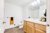 Bright and modern bathroom featuring elegant wood cabinets, a sleek marble countertop, and tasteful decor.