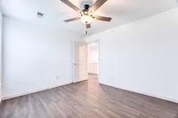 Bright and spacious room featuring sleek hardwood floors and a modern ceiling fan, offering an inviting canvas for personalized design.
