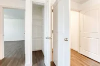 Bright apartment with elegant white doors, spacious closets, and sleek hardwood floors inviting modern living.