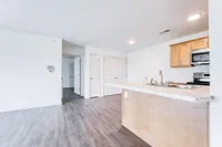 Bright and modern open-concept apartment kitchen with sleek countertops and stainless steel appliances.