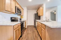 Modern kitchen with elegant wood cabinets, marble countertops, and stainless steel appliances, ideal for culinary creativity.