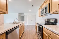 Modern kitchen featuring sleek marble countertops, stainless steel appliances, and elegant wooden cabinetry.
