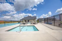Inviting outdoor pool area with clear blue water, set against a picturesque sky, providing a perfect space for relaxation and leisure.