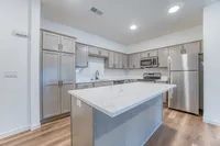 Modern kitchen with elegant marble countertop island, sleek cabinetry, and stainless steel appliances creating a sophisticated cooking space.