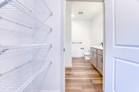 Bright and spacious bathroom with elegant wooden flooring and generous storage shelves, offering a modern and inviting atmosphere.