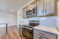 Modern kitchen featuring sleek stainless steel appliances, elegant wooden cabinetry, and polished marble countertops.