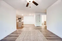 Elegant open-concept living space with modern kitchen view and stylish wood flooring, ideal for comfortable living.