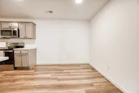 Modern kitchen with sleek stainless steel appliances, elegant cabinetry, and inviting wood-style flooring.