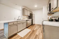 Modern kitchen with sleek stainless steel appliances, elegant wooden flooring, and stylish marble countertops.