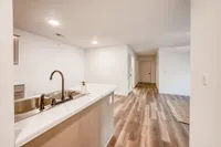 Inviting apartment interior featuring a modern kitchen with marble countertops and elegant wood flooring throughout.