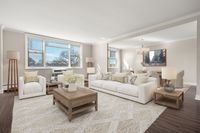 Inviting open-concept living and dining area with elegant decor, featuring large windows, plush seating, and abundant natural light at Parkside Place, apartments in Cambridge, MA