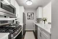 Sleek modern kitchen, statuario quartz countertops, six burner gas stove, stainless steel appliances at Parkside Place, apartments in Cambridge, MA