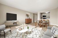 Chic living and dining area featuring modern decor, large windows for ample natural light, bar seating at the kitchen counter, with sleek stainless-steel appliances, six burner gas stove and quartz countertops