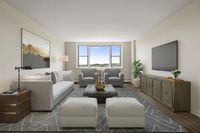 Elegant living room with plush grey sofa, modern armchairs, and expansive windows offering scenic views. Stylish decor and ample natural light create a welcoming atmosphere at Parkside Place, apartments in Cambridge, MA