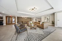 Elegant communal living area with contemporary decor, featuring a plush sectional sofa, modern leather chairs, and stylish lighting perfect for relaxation and socializing.