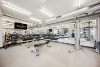 Modern fitness center with state-of-the-art equipment, including free weights, benches, and mirrored walls for an invigorating workout experience.