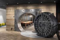 Unique apartment feature with a repurposed vault door leading to an elegant entertainment area with ambient lighting.