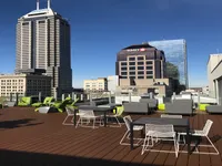 Chic rooftop terrace with stylish outdoor seating offering stunning city skyline views on a sunny day.