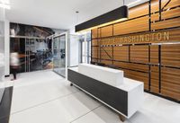 Modern lobby featuring sleek design with a minimalist reception desk, stylish wood paneling, and elegant lighting at 130 E. Washington.
