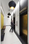 Modern hallway with sleek elevators and artistic lighting design, offering a sophisticated apartment living experience.