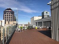 Inviting rooftop terrace with modern seating, stunning cityscape views, and ample space for relaxation under a bright blue sky.
