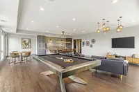 Elegant entertainment room with a modern pool table, stylish seating, and chic lighting fixtures, perfect for social gatherings.