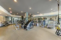 Luxurious fitness center with state-of-the-art equipment, including treadmills, elliptical machines, and weight training area, perfect for an energizing workout.