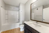Modern bathroom with elegant fixtures, spacious bathtub, and sleek vanity, beautifully designed for comfort and style.