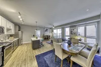 Modern open-concept kitchen and dining area with stylish stainless steel appliances, sleek cabinetry, and ample natural light.
