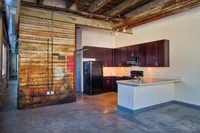 Chic industrial-style kitchen with exposed beams, rustic wood accents, and sleek modern cabinetry.