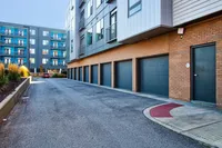 Modern apartment exterior with sleek design, private garages, and vibrant landscaping.