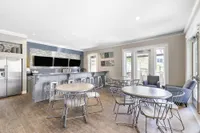 Chic communal lounge with modern furnishings, sleek bar area, and bright natural lighting, perfect for social gatherings and relaxation.