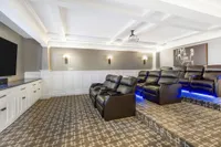 Luxurious home theater with plush leather recliners and ambient lighting, offering an elegant entertainment experience.