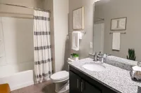Modern bathroom with elegant granite countertop, stylish fixtures, and inviting bathtub, perfect for relaxation.