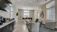 Bright and modern communal space featuring plush seating, stylish decor, and a coffee station. Ideal for relaxation and gatherings.