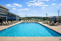 Inviting outdoor pool area with sun loungers and umbrellas, perfect for relaxation and leisure on a sunny day.