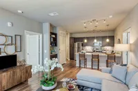 Contemporary open-concept living space with elegant decor, modern kitchen, and cozy seating area featuring beautiful natural lighting.