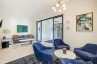Modern apartment lobby with stylish blue seating, contemporary art, and elegant lighting, offering a welcoming atmosphere.