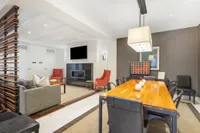 Inviting modern living area with stylish decor, featuring a cozy fireplace, chic dining table, and plush seating.
