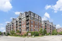 Elegant brick apartment complex with modern balconies and beautifully landscaped surroundings in a vibrant neighborhood.