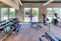 Bright and modern fitness center with state-of-the-art gym equipment, large windows, and sleek design.