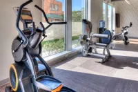 Bright and modern gym with state-of-the-art exercise equipment, featuring cardio machines and strength training stations.