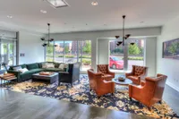 Elegant and spacious living room with plush seating, large windows offering abundant natural light, and modern decor.