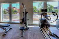 Modern fitness center with state-of-the-art exercise equipment and large windows offering a scenic view.