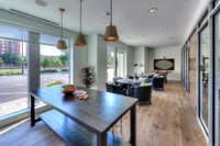 Modern apartment lounge with large windows, natural light, and stylish seating creating a welcoming and sophisticated atmosphere.
