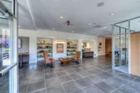 Spacious and modern lobby featuring elegant seating, stylish bookshelves, and contemporary decor with natural light streaming in.